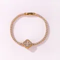 Close-up view of a gold-plated tennis bracelet featuring a sparkling four-leaf clover motif - Gold White Zirconia