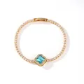 Close-up of gold plated tennis bracelet with sparkling blue clover flower charm detail - Gold Plated Blue Zirconia