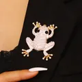 Frosch-Brosche in Gold mit weißen Perlen und Straßsteinen auf schwarzem Revers - Frosch / Weiß