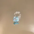 Detailed close-up of a blue beaded flower ring on a reflective golden surface. - Blue Flower Style (HR3453) / Blue
