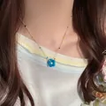 Detailed close-up of a colorful dopamine flower beaded necklace on a model's collarbone. - Blue