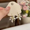 Elegant white floral petal earrings with zircon centers on a textured jewelry card. - Ear Buckle / Gold-White