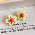 Macro view of dopamine flower stud earrings with yellow petals and pink centers - Yellow and Pink