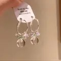 Close-up of silver hoop earrings with crystal beads and a clear glass ball pendant. - Iron Style / Silver-Green-Yellow