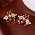 Detail view of exquisite vintage insect earrings with sparkling crystals and red enamel - Earrings Only / Gold-Red
