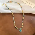 Perlenhalskette im Boho-Stil mit blauem Katzenaugen-Anhänger und goldenen Blumenelementen - Halskette - Gold - Blau
