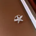 Detailed view of a sparkling starfish-shaped ear cuff for non-pierced ears in silver - Starfish / Silver