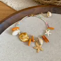 Detail view of summer shell beaded anklet with golden starfish and orange stones. - 58# Bracelet / Gold-Multicolor