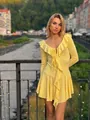 Detail of yellow dress featuring ruffled neckline and delicate front tie strings - Yellow