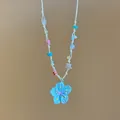 Dettaglio di una collana di perline colorate con pendente a fiore blu in resina estiva - Blu