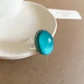 Macro view of a minimalist teal oval resin ring with a transparent band for women - 28# Lake Blue