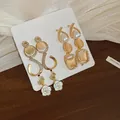 Detailed view of elegant gold earrings with cat's eye stones and white floral drops - Camellia/Opal-look (32# Silver Earring Post)