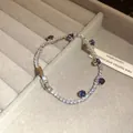 Elegant silver-toned tennis bracelet with purple zircons displayed in a grey jewelry box - 23# Bracelet / Silver Purple