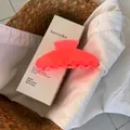 Detailed view of a large neon pink jelly hair claw clip on a white minimalist box - Fluorescent Orange