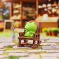 Miniature resin frog fishing figurine sitting on a wooden rocking chair for desk decor - Fishing Frog Figure (1256-3)