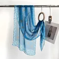 Blue translucent silk scarf featuring white Chinese calligraphy and traditional orange seal - Ink Wash Blue