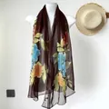Brown sheer scarf with blue and orange floral prints on a white mannequin - Ink Peony Coffee