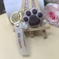 Détail du porte-clés patte de chat en silicone avec lanière Lucky Day et anneau doré - Marron