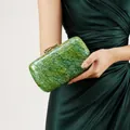 Elegante bolso de noche verde esmeralda efecto mármol con cierre dorado llevado por modelo - Verde