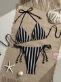 Flat lay of black and white striped knit bikini with side ties and seashell decor - Black