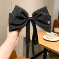 Große schwarze Haarschleife aus Perlgarn mit Strassverzierung und langen Bändern - Schleife mit Metall-Schmetterling-Dekor / Schwarz