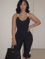 Detail of black V-neck jumpsuit with white straps and elegant ruffled hem design - S / Black