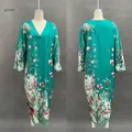 Detail of green V-neck maxi dress featuring vibrant floral print and long sleeves - S / Green