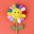 Handmade crochet rainbow sunflower decoration with smiling face on orange background - Large Smiling Rainbow Sunflower / Multicolor