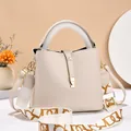 Cremeweiße Bucket Bag aus Litschi-Leder mit Jacquard-Gurt und Goldschnalle - Weiß
