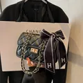 Classic black quilted shoulder bag with gold chain strap and silk bow detail - Black