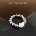 Dettaglio anello di perle grigie con testa di gatto in conchiglia e riflesso lucido - Perla Grigia (Gatto Conchiglia)
