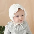 Detail of white cotton lace baby bonnet with embroidered ruffles and chin tie - White Gauze Hat