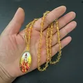 Dettaglio ravvicinato del ciondolo ovale Guanyin con perline gialle e cornice dorata - Catena di Perle d'Ambra