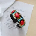 Detail of bohemian woven cuff with red oval stone and blue beads on vintage background - 3-Red Stone Crystal Flower