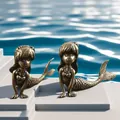 Detail view of two antique bronze mermaid figurines with intricate scale textures - Mermaid