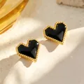Gros plan sur les puces d'oreilles cœur dorées avec incrustation noire et bord perlé - Boucles d'oreilles (e198B) / Nacre Noire
