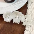 Three-flower marble white acetate hair claw clip with pearls on a dark wood table - 8.5cm / Gem White