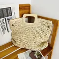 Handgefertigte gewebte Stroh-Strandtasche mit quadratischen Holzgriffen auf Holzstuhl - Beige