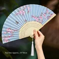 Blue Chinese folding fan with pink cherry blossoms and elegant white silk tassel - 69 Flower Dance