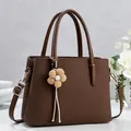 Elegant dark brown lychee textured tote bag with a beige floral pendant accessory - Coffee
