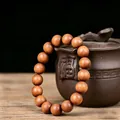 Indonesian sandalwood prayer beads bracelet with natural wood grain texture on prop jar - Premium Single Loop / 12mm*17 Beads
