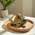 Dettaglio macro di una tartaruga in ottone su un vassoio di legno e luce calda - Tartaruga / Bronzo