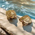 Close-up of solid brass turtle figurines with antique finish on a rock by the water - Mini Turtle Stamp