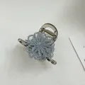 Detail of light blue beaded flower hair claw clip with transparent resin base - Flower Blue