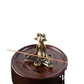 Macro detail of brass frog incense holder with vintage finish on a dark wooden base - Zen Meditation Frog / Bronze