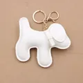 Detailed view of white PU leather puppy charm with stitching and golden keyring - Dog Keychain / White