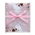 Detail of pink glitter laser-cut wedding invitation with a satin ribbon and floral pattern - Pink