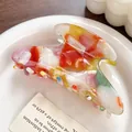 Colorful acetate marble hair claw clip with vibrant swirling patterns on white ceramic tray - Tropical Red