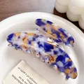 Blue and white marble acetate hair claw clip for thick hair shown on a ceramic plate - Blue Brown
