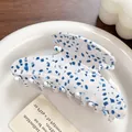 Blue terrazzo patterned acetate hair claw clip displayed on a white ceramic plate - Blue Spot Jasper